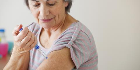 A woman injecting medicine to her upper arm.