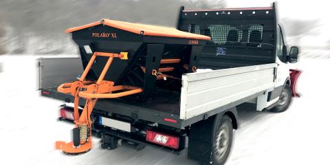 Small drop-side truck with a Lehner winter service salt spreader installed in the load bed.